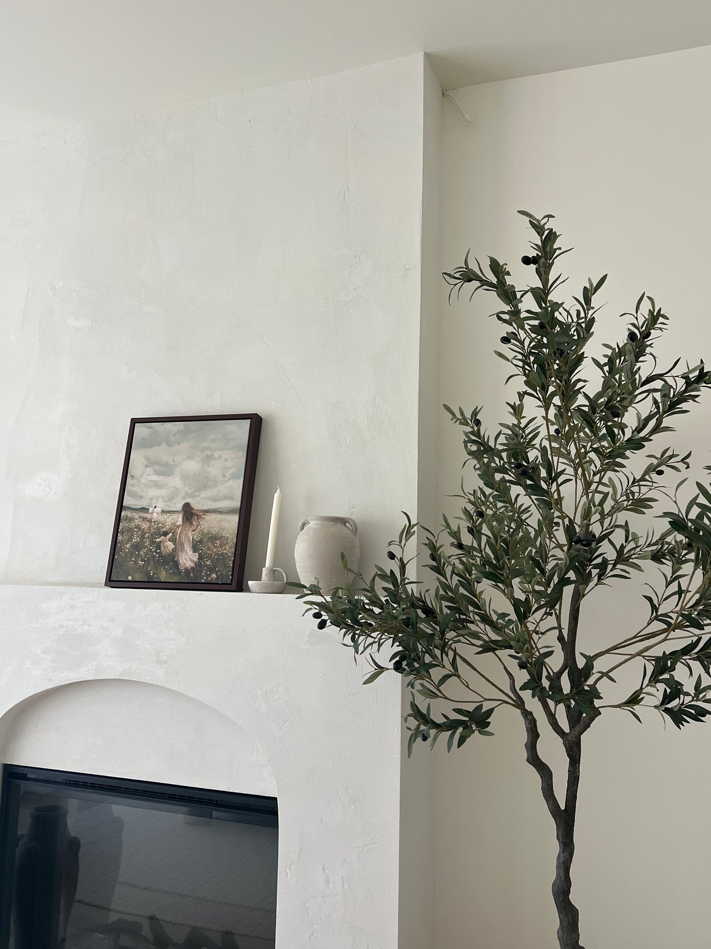 Modern interior with a plant, framed picture, and decorative items on a white wall. Following Him Canvas modern Christian wall art by Christian artist, walking with Jesus in faith.