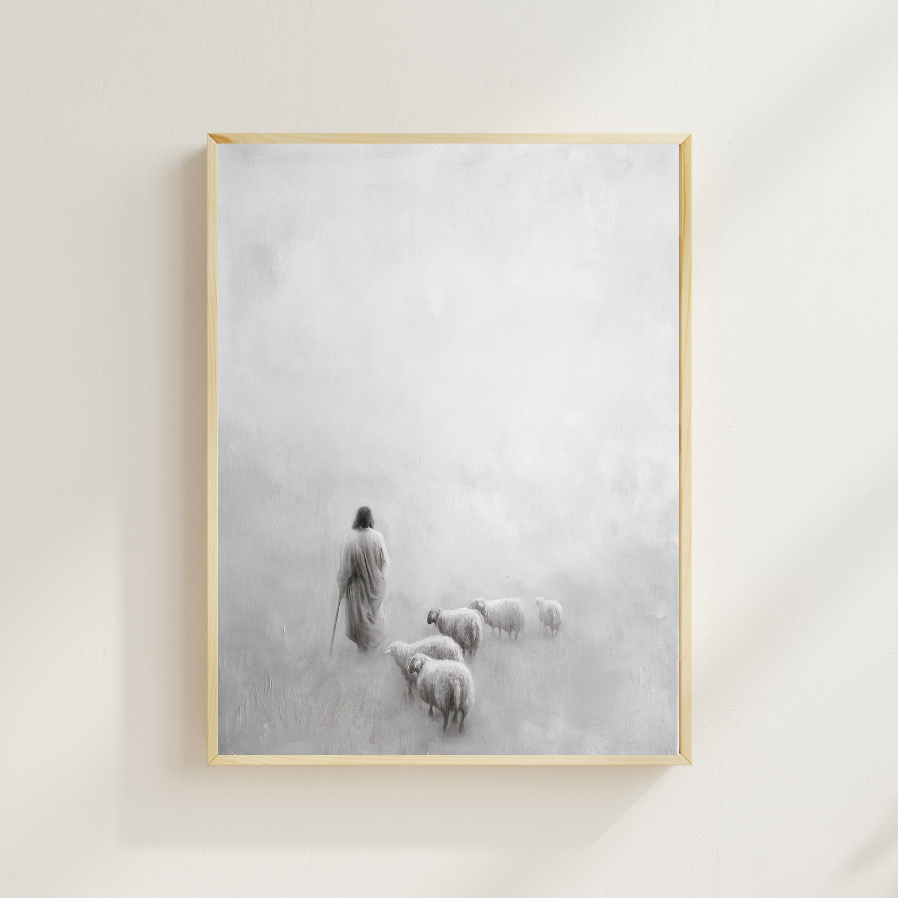 Framed artwork of a shepherd with sheep in a misty landscape on a white wall. Gentle Shepherd B&W Paper print Christian wall art modern, Jesus the Shepherd, devotion-inspired.